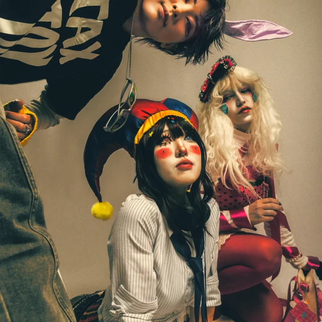 the amazing digital circus cosplay Pomni, Jax, and Ragatha in warm fashion editorial portrait.