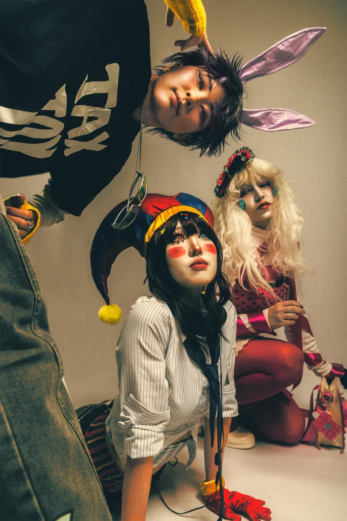 the amazing digital circus cosplay Pomni, Jax, and Ragatha in warm fashion editorial portrait.