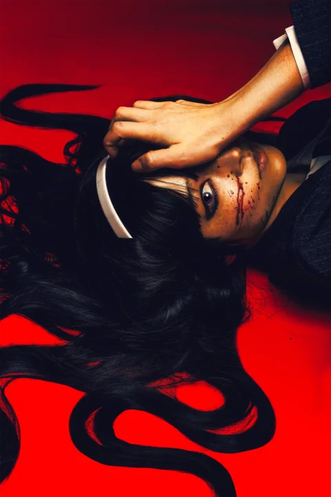 Tomei from Junji Ito cosplay with blood on her cheek on red background by influencer me.bigboy in haunting, horror editorial portrait.